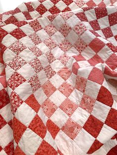 a red and white checkered quilt on a bed