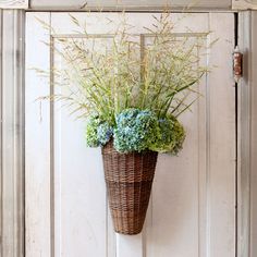 a basket with some flowers in it hanging on a wall