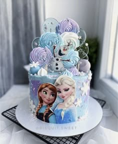 there is a cake decorated with frozen princesses