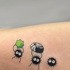 three small black bugs on the arm and one green bug in the middle with googly eyes