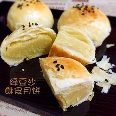 four rolls with black sesame seeds on them sitting on top of a plate next to some rice