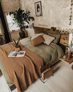 a bedroom with a bed, plant and pictures on the wall