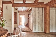 a room with wooden walls and flooring next to a table in front of a doorway