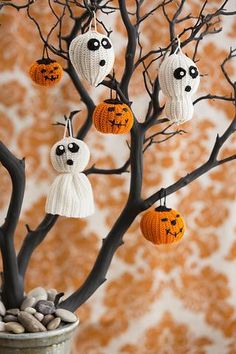 a potted plant with halloween decorations hanging from it's branches