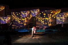 a man and woman standing in front of lighted screens