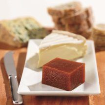 a piece of cake on a plate next to a knife and some bread slices in the background