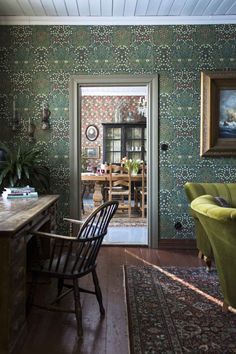 a living room filled with furniture and a painting hanging on the wall next to a doorway