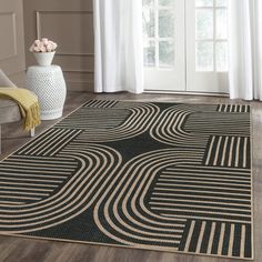 a black and white area rug with an abstract design on the floor in front of a window