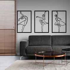 a living room with three black and white paintings on the wall