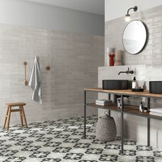 a bathroom with black and white tiles on the floor, two sinks and a mirror