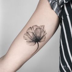 a woman's arm with a flower tattoo on the left side of her arm