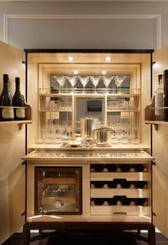 a wine cellar with many bottles and glasses on the shelves, along with several empty glassware