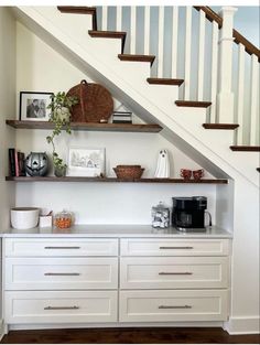 some shelves under the stairs with pictures on them