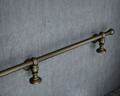 an old fashioned metal rail on a wall in a room with concrete walls and tile flooring