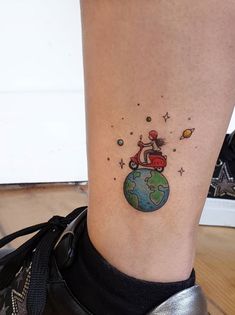 a woman's foot with a small tattoo on the side of her leg that has a cat sitting on top of it