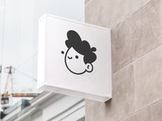 a sign on the side of a building with a woman's face drawn on it