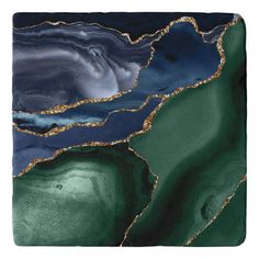 a green and black marble with gold foil on the edges is seen in this image