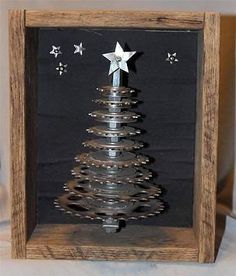 a metal christmas tree in a wooden frame with stars on the top and silver decorations around it