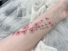 a woman's arm with pink flowers on it