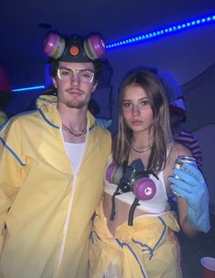 a man and woman dressed up in costumes standing next to each other with headphones on