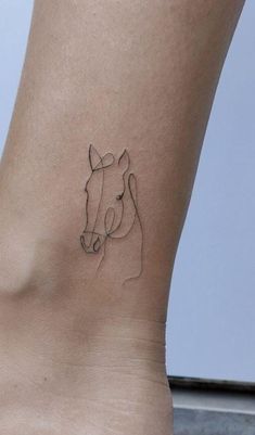 a small tattoo on the ankle of a woman's foot, depicting a horse