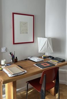 a wooden desk topped with books and a lamp