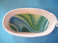 a white basket with green and blue swirls on it