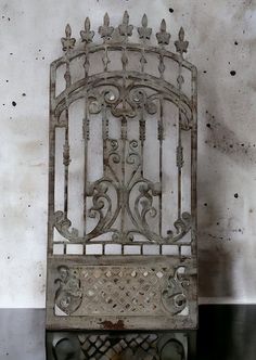 an old iron bed frame sitting against a wall