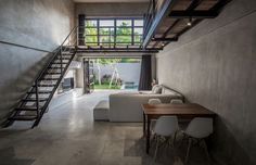 an open living room with stairs leading up to the second floor and dining table in front of it