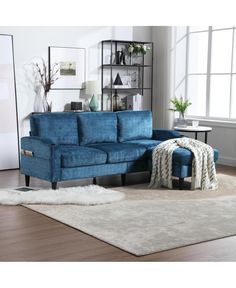 a blue sectional sofa sitting on top of a white rug