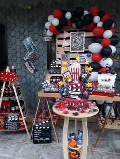 a table topped with lots of balloons and other items in front of a sign that says cinema