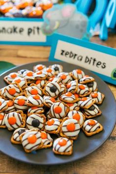 there is a plate full of cookies with orange and white icing on it, along with other desserts