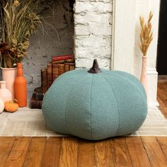 a large blue bean bag sitting on top of a wooden floor next to a fireplace