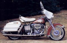 a red and white motorcycle parked on top of a dirt field