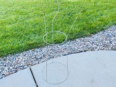 a metal planter sitting on top of a cement slab next to a grass field