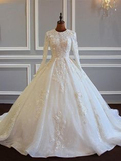 a wedding dress on display in front of a wall