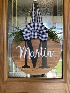 a door hanger with the word martin on it and a gingham bow