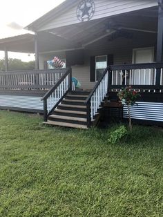 there is a porch with stairs leading up to the front door and side yard area