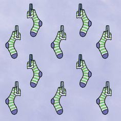 many socks with green and blue stripes on them are hanging in the air above clouds