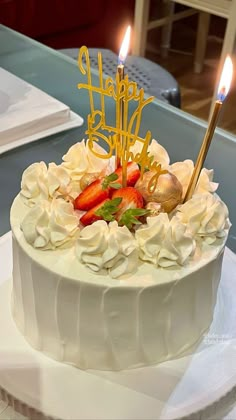 a white cake with strawberries and candles on it