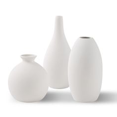 three white vases sitting next to each other in front of a white background,