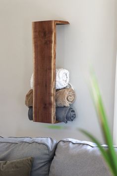 a wooden shelf with towels on top of it in the corner of a living room