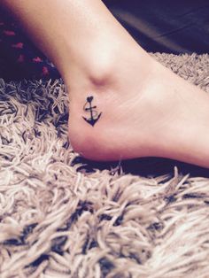 a small anchor tattoo on the foot