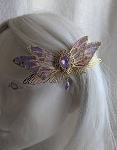 This gorgeous alligator hair clip features fairy wings with a opalescent gem in the middle. A drop crystal hangs from the center for an added touch. Choose your color! Perfect for special occasions or to add a bit of magic to your everyday! Fantasy Hair Clip, Hair Clip Design Ideas, Handmade Fantasy Headpieces For Gifts, Fey Jewelry, Faerie Jewelry, Fantasy Accessories, Magical Hair, Fairy Accessories, Alligator Hair Clip