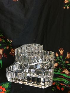 two clear glass containers sitting on top of a black cloth