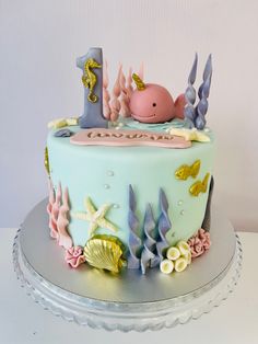 a blue cake decorated with sea animals and seashells