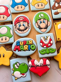 decorated cookies are arranged on a table with mario and other characters in the shape of hearts