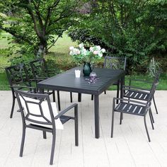 an outdoor dining table and chairs with flowers on it