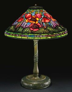 a lamp that is on top of a black surface with a flower design on it