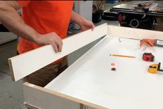 a man is working on an unfinished piece of furniture